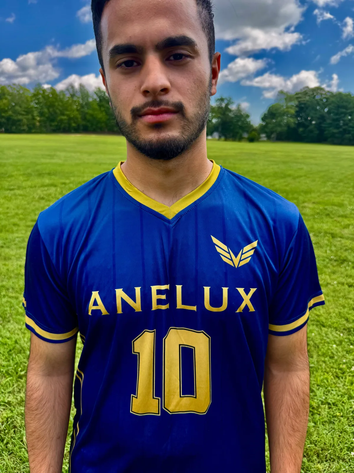 Close portrait of an athlete wearing a blue and gold ANELUX number 10 soccer jersey